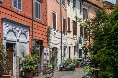 a street with a scooter parked next to a building at iFlat Trastevere Bianca's House in Rome