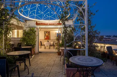 an outdoor patio with tables and chairs and an arbor at Antica Dimora Delle Cinque Lune in Rome