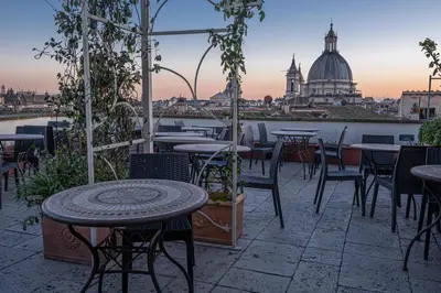 a patio with tables and chairs and a view of the city at Antica Dimora Delle Cinque Lune in Rome