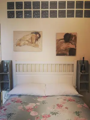 a bedroom with a bed with paintings on the wall at Relais Villa Fiorelli in Rome