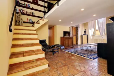 a living room with a staircase and a table at Campo Dei Fiori Home in Rome
