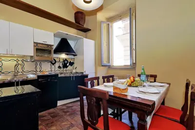 a kitchen with a wooden table and a dining room at Campo Dei Fiori Home in Rome