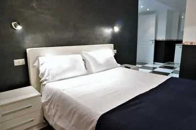 a bedroom with a white bed with a black wall at Luxury Vatican Rooms in Rome