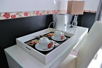 a white drawer with two cups and plates on a table at Luxury Vatican Rooms in Rome