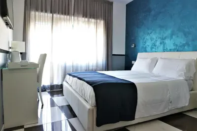 a bedroom with a large bed with a blue wall at Luxury Vatican Rooms in Rome