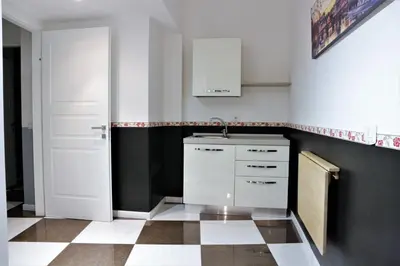 a kitchen with white cabinets and a black and white tile floor at Luxury Vatican Rooms in Rome