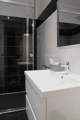 a white bathroom with a sink and a shower at Luxury Vatican Rooms in Rome