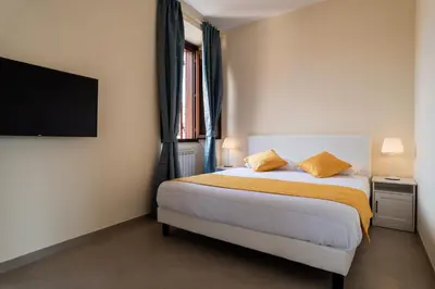 a bedroom with a bed and a flat screen tv at Minerva Monks Inn in Rome