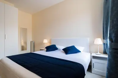 a bedroom with a large bed with blue pillows at Minerva Monks Inn in Rome