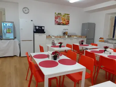 a kitchen with red and white tables and red chairs at Minerva Monks Inn in Rome