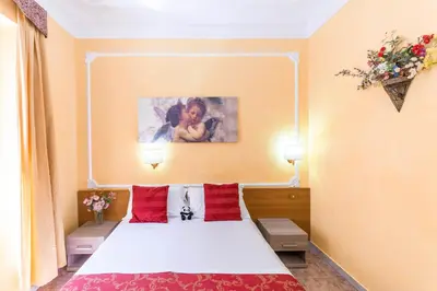 a hotel room with a bed with red pillows at Downtown Accommodation in Rome