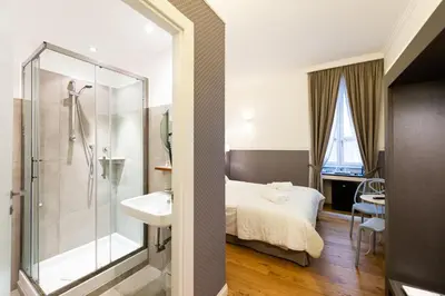 a bathroom with a bed and a shower and a sink at La Maison di Sant'Anna in Rome