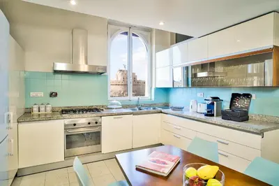 a kitchen with white cabinets and a table and a window at Appartamento a Castel Sant'Angelo con terrazza in Rome