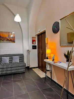 a living room with a couch and a clock on the wall at AMP Vatican House in Rome