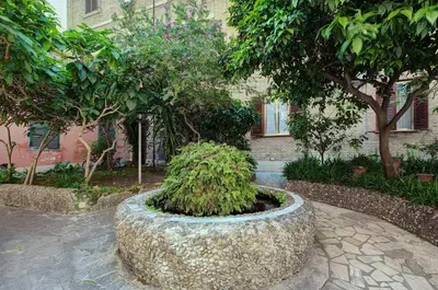 a large stone planter in front of a building with trees at AMP Vatican House in Rome