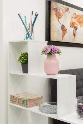 a pink vase with flowers on a white shelf at chèri luxury suite in Rome