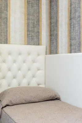 a white bed with a white headboard in a bedroom at chèri luxury suite in Rome