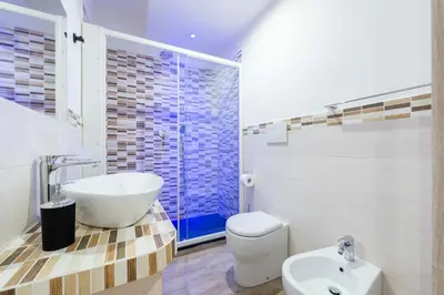 a bathroom with a tub and a toilet and a sink at chèri luxury suite in Rome