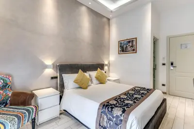 a bedroom with a large white bed and a chair at Rose Suite in Rome