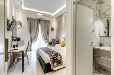 a bedroom with a bed and a desk and a sink at Rose Suite in Rome
