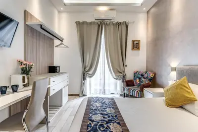 a room with a bed and a chair and a window at Rose Suite in Rome