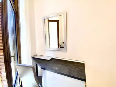 a mirror on a wall next to a desk at Rose Suite in Rome