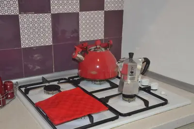 a red tea pot sitting on a stove top at Colosseum relax family apartament in Rome