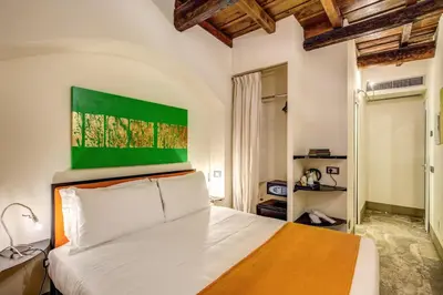 a bedroom with a bed with a green painting above it at Casa Argileto in Rome