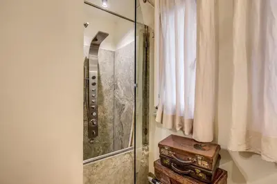 a bathroom with a shower and a wooden stool at Casa Argileto in Rome