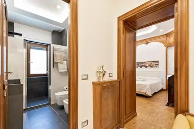 a bathroom with a toilet and a bed in a room at First Class Rome Apartments in Rome