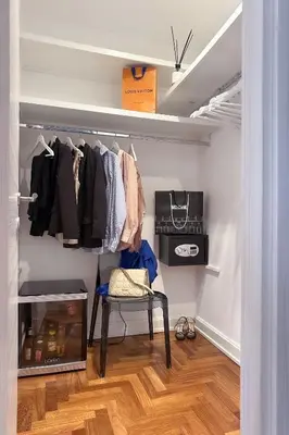 a walk in closet with a chair and clothes at Hadrianus Temple Suites - The Venue Collection in Rome