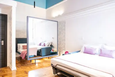 a bedroom with two beds and a mirror at Hadrianus Temple Suites - The Venue Collection in Rome