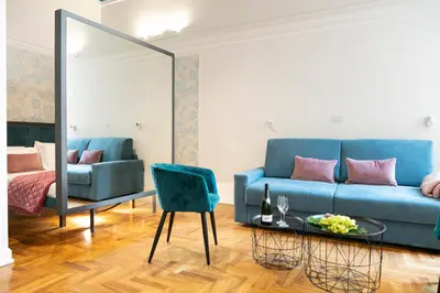 a living room with a blue couch and a table at Hadrianus Temple Suites - The Venue Collection in Rome