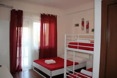 a small room with two bunk beds with red curtains at Domus Vatican Holiday's in Rome
