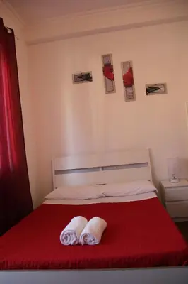 a bedroom with a red bed with two towels on it at Domus Vatican Holiday's in Rome