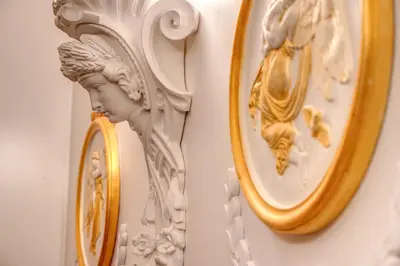 a white wall with a mirror and a statue at Nakissa Inn in Rome