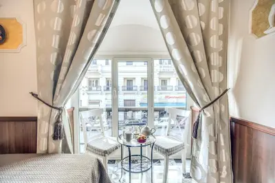 a room with a bed and a table and a window at Nakissa Inn in Rome