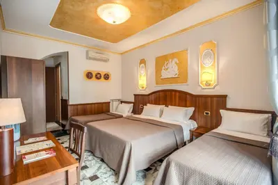 a hotel room with two beds and a table at Nakissa Inn in Rome
