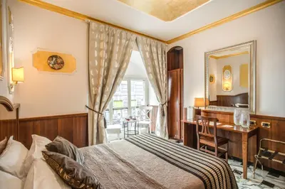a bedroom with a bed and a desk and a mirror at Nakissa Inn in Rome