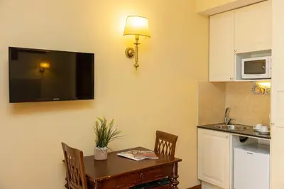 a kitchen with a table and a television on the wall at InternoUno Deluxe in Rome
