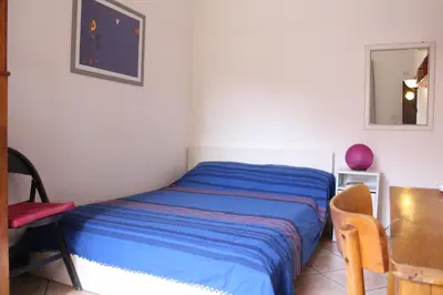 a bedroom with a bed and a chair and a mirror at Hazelrome apartment in Rome