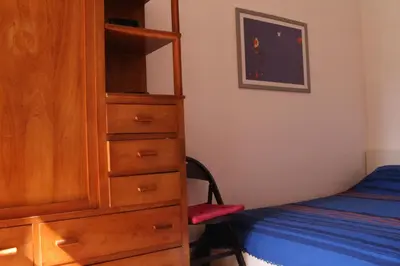 a bedroom with a wooden cabinet next to a bed at Hazelrome apartment in Rome