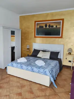 a bedroom with a bed with a blue comforter at Piramide Gold in Rome