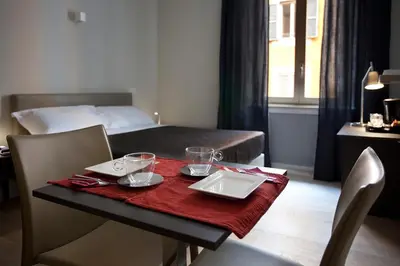 a room with a table and a bed and a table and chairs at Regola Suite in Rome