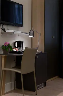 a desk with a chair and a television and a lamp at Regola Suite in Rome