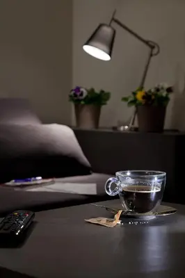 a cup of coffee on a table with a remote control at Regola Suite in Rome