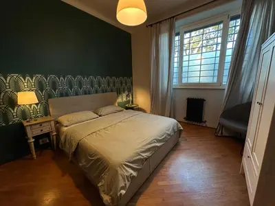 a bedroom with a bed and a large window at Domus Giulio Cesare Apartment in Rome