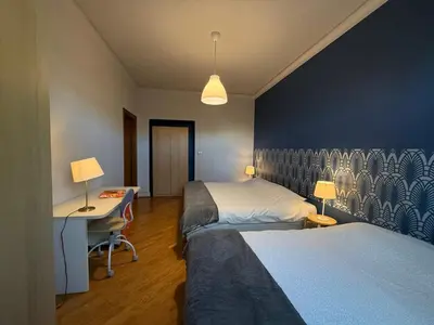 a hotel room with two beds and a desk and a desk at Domus Giulio Cesare Apartment in Rome