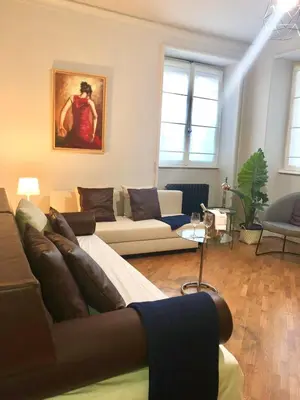 a living room with a couch and a painting on the wall at Domus Giulio Cesare Apartment in Rome