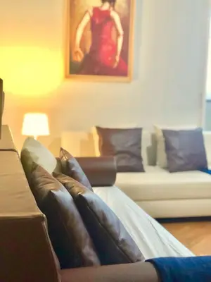 a living room with a couch and a painting at Domus Giulio Cesare Apartment in Rome